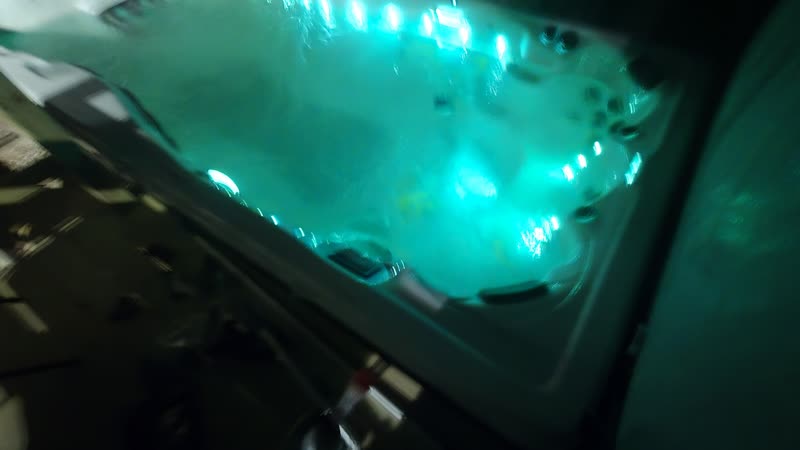 Swim spa lit teal with the water swirling