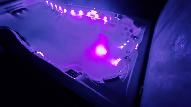 Swim spa lit magenta, lights low